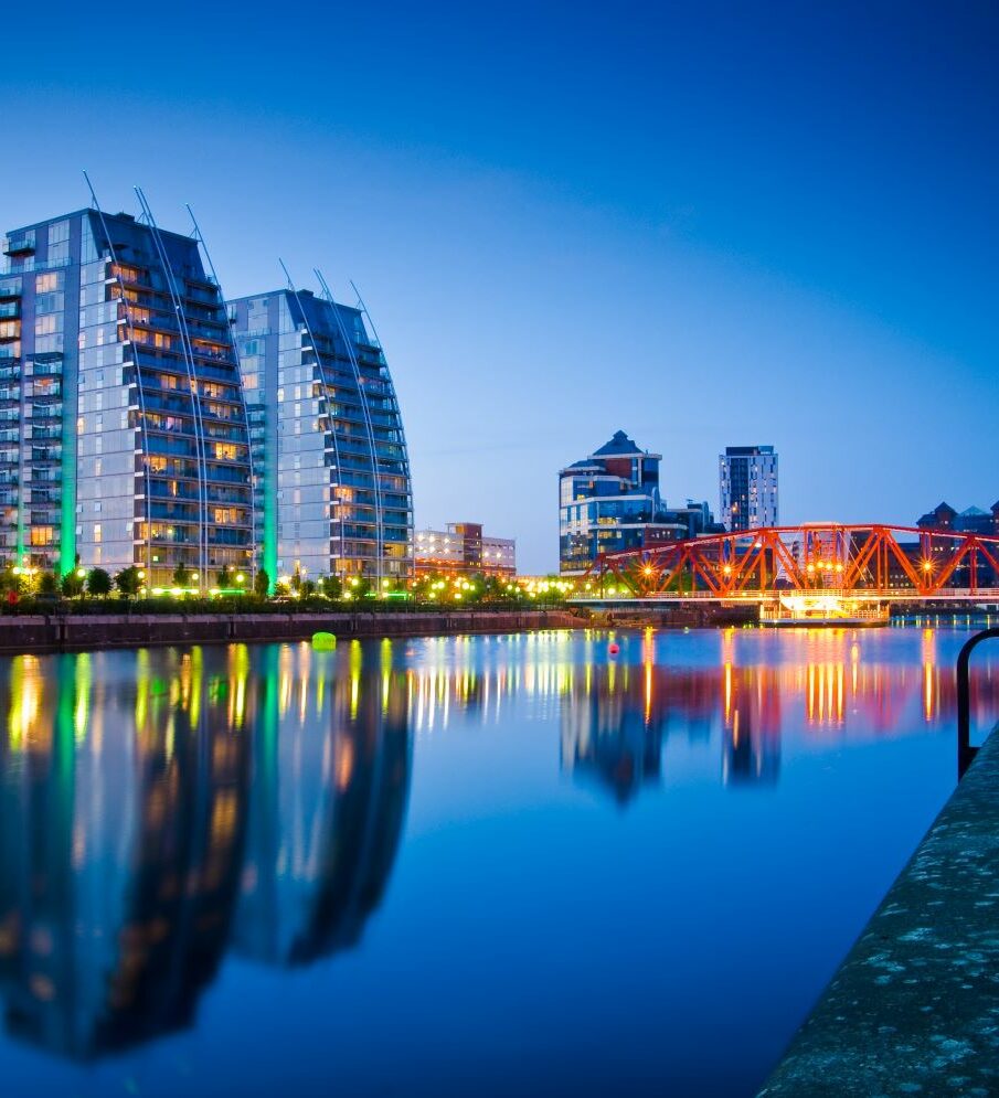 Image of buildings on river with reflections at dusk