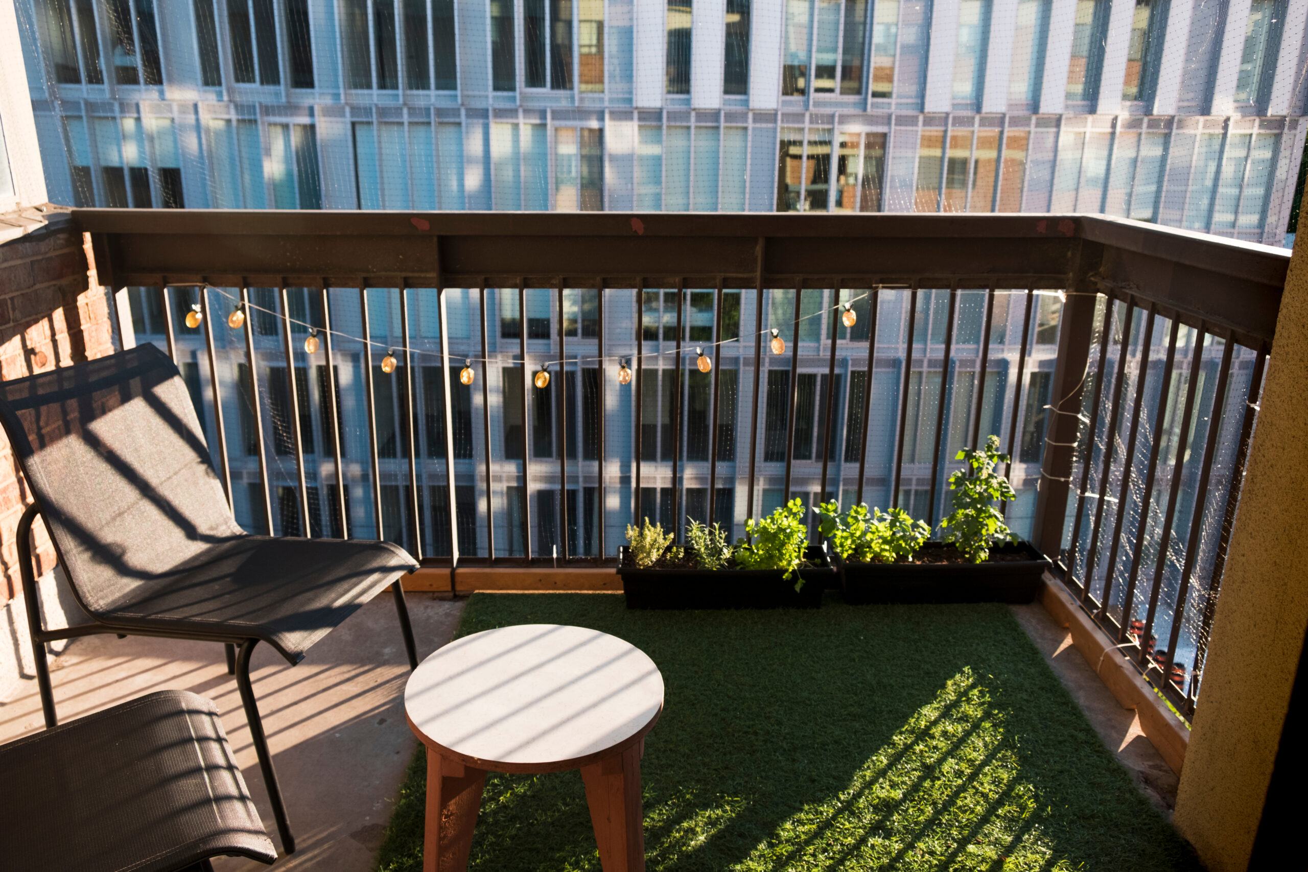 Apartment,Balcony,In,City,With,Grass,Turf,And,Potted,Plants.